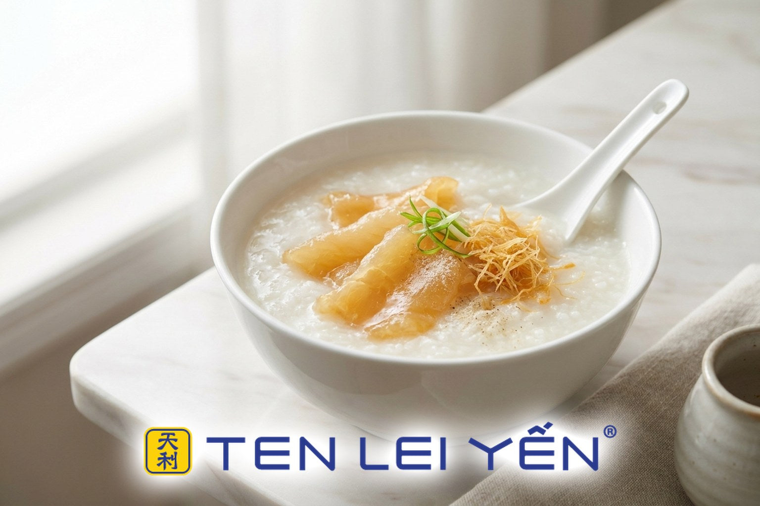 A bowl of finished fish maw and dried scallop congee garnished with scallion and shredded scallop