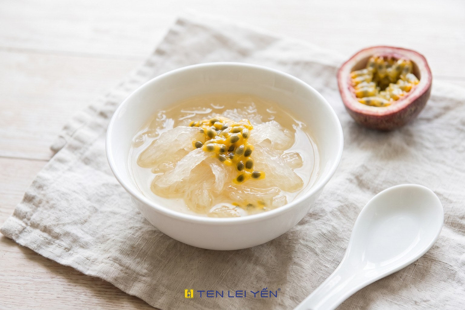 Chilled edible bird's nest topped with fresh passion fruit pulp and seeds in a white porcelain bowl