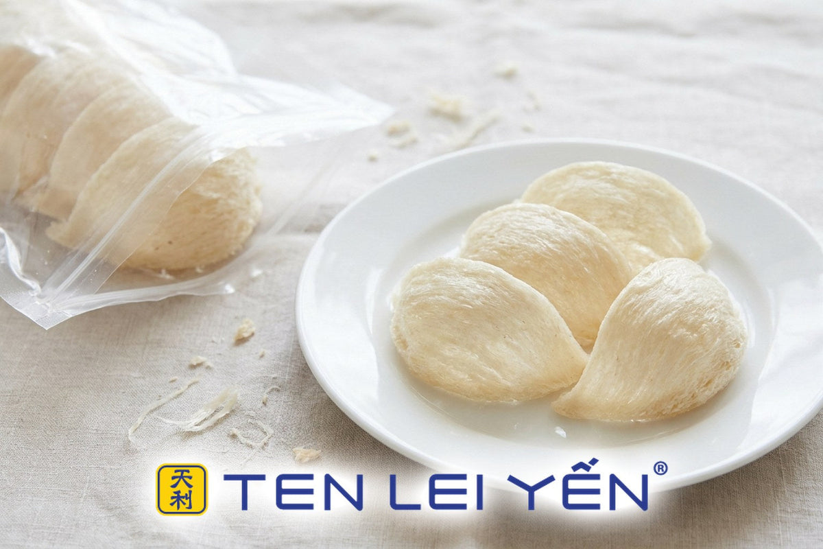 Three dried edible bird's nests on a white porcelain plate beside an opened clear vacuum-sealed pouch