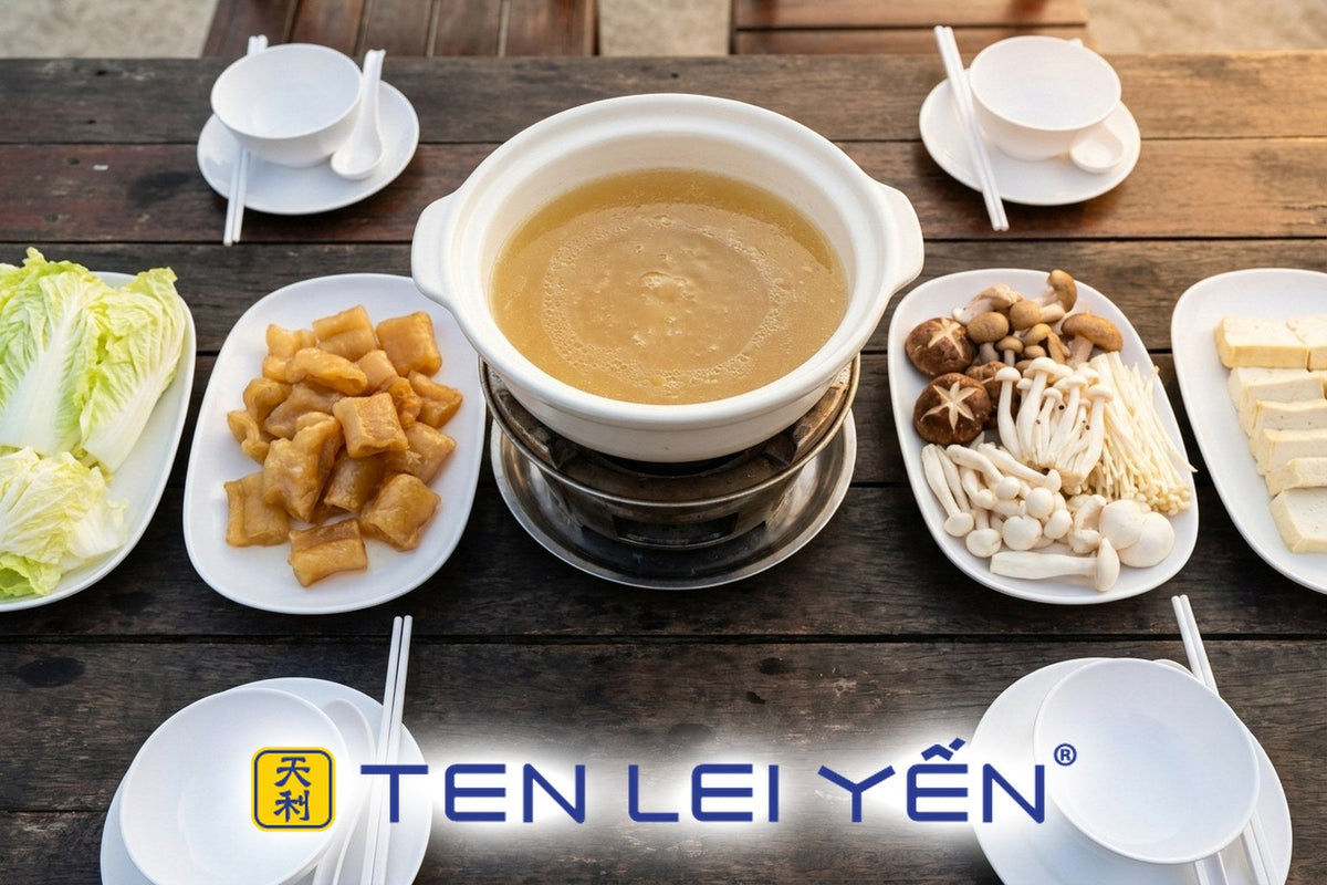 Fish maw hot pot at the table with clear chicken broth, napa cabbage, mushrooms, and tofu