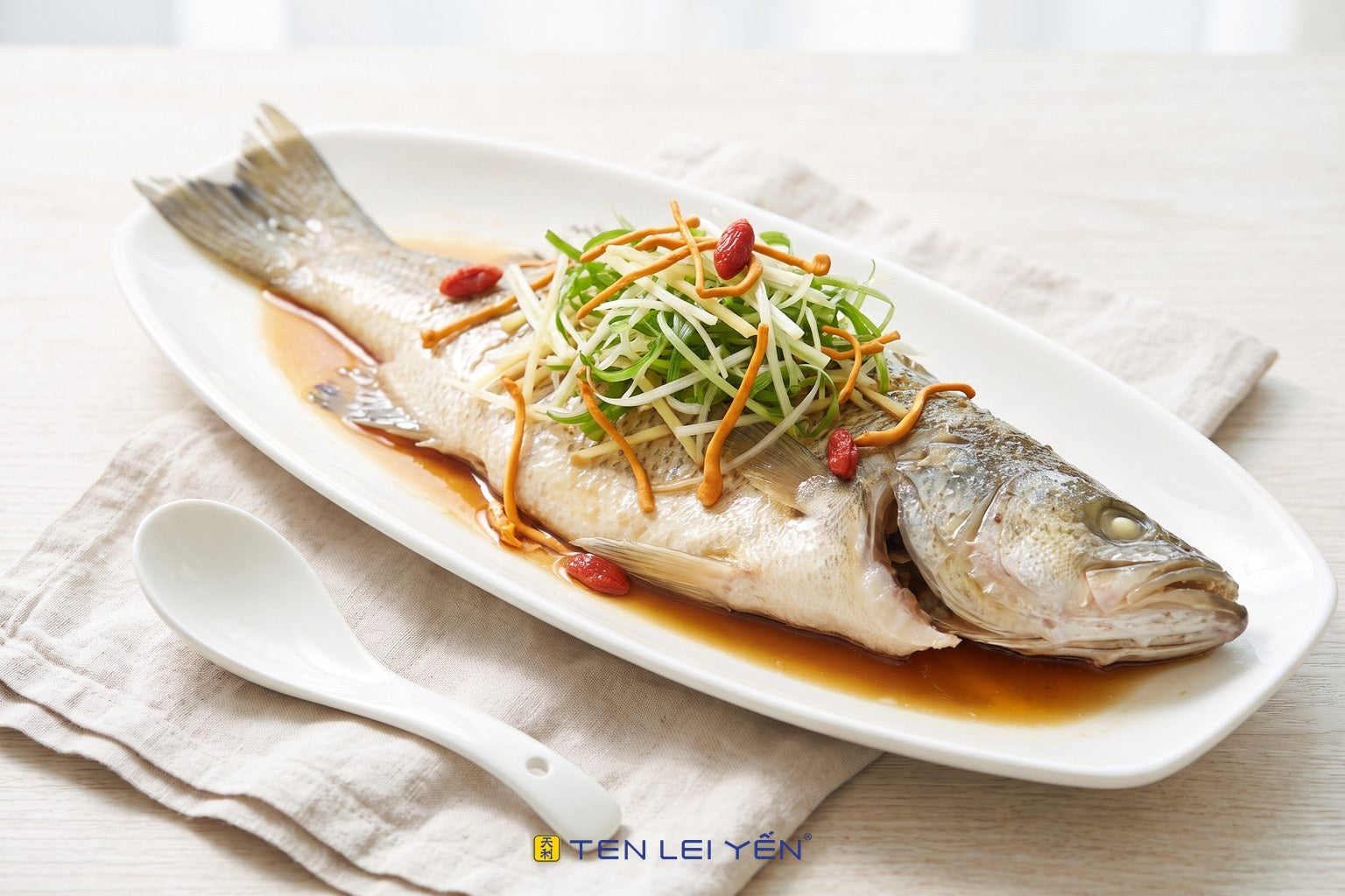 Cantonese steamed white fish with cordyceps, scallion, ginger, and goji on a white porcelain platter