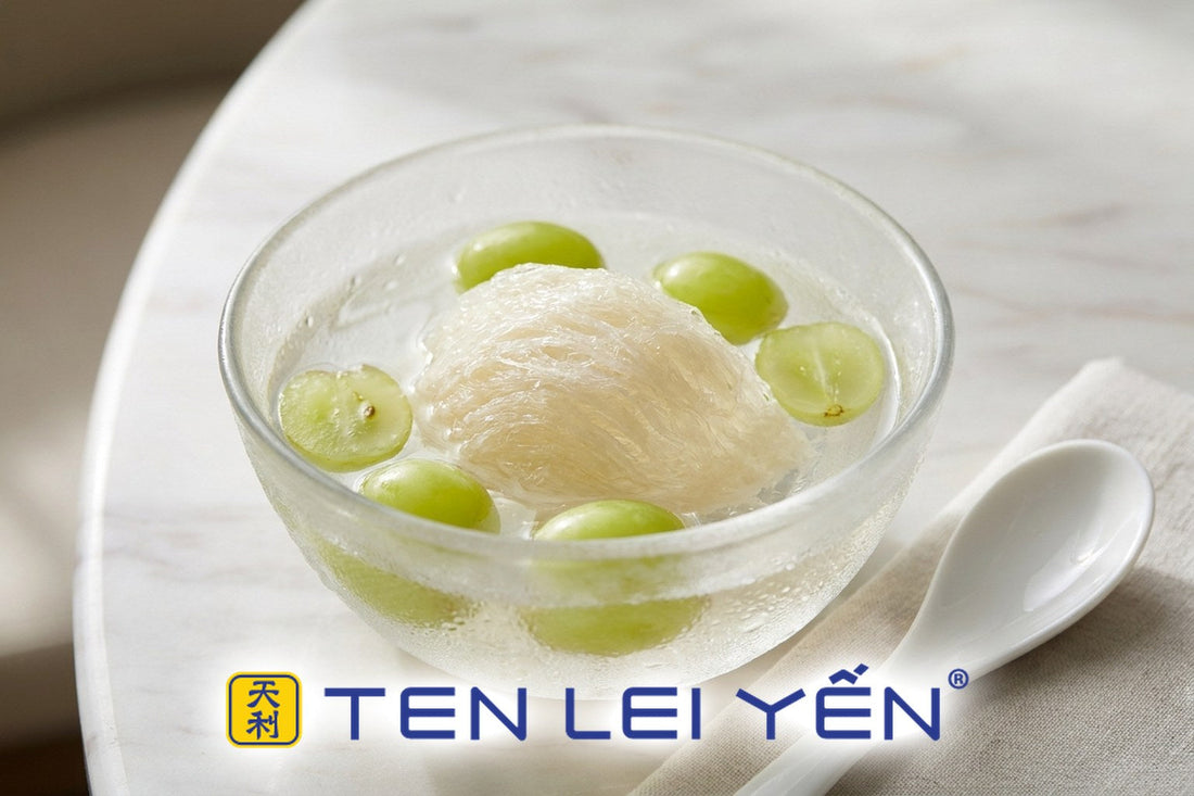 Chilled bird's nest dessert with muscat grapes in a glass bowl beside a white porcelain spoon