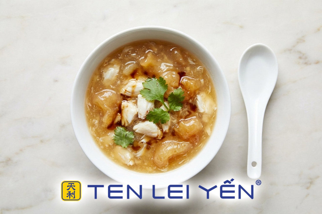 A white bowl of glossy thick fish maw and crab meat soup with a white porcelain spoon beside it