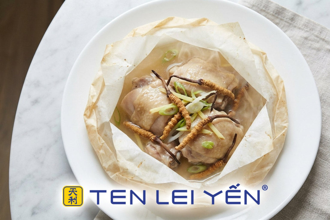 Opened parchment packet with steamed chicken and whole wild cordyceps on a white plate