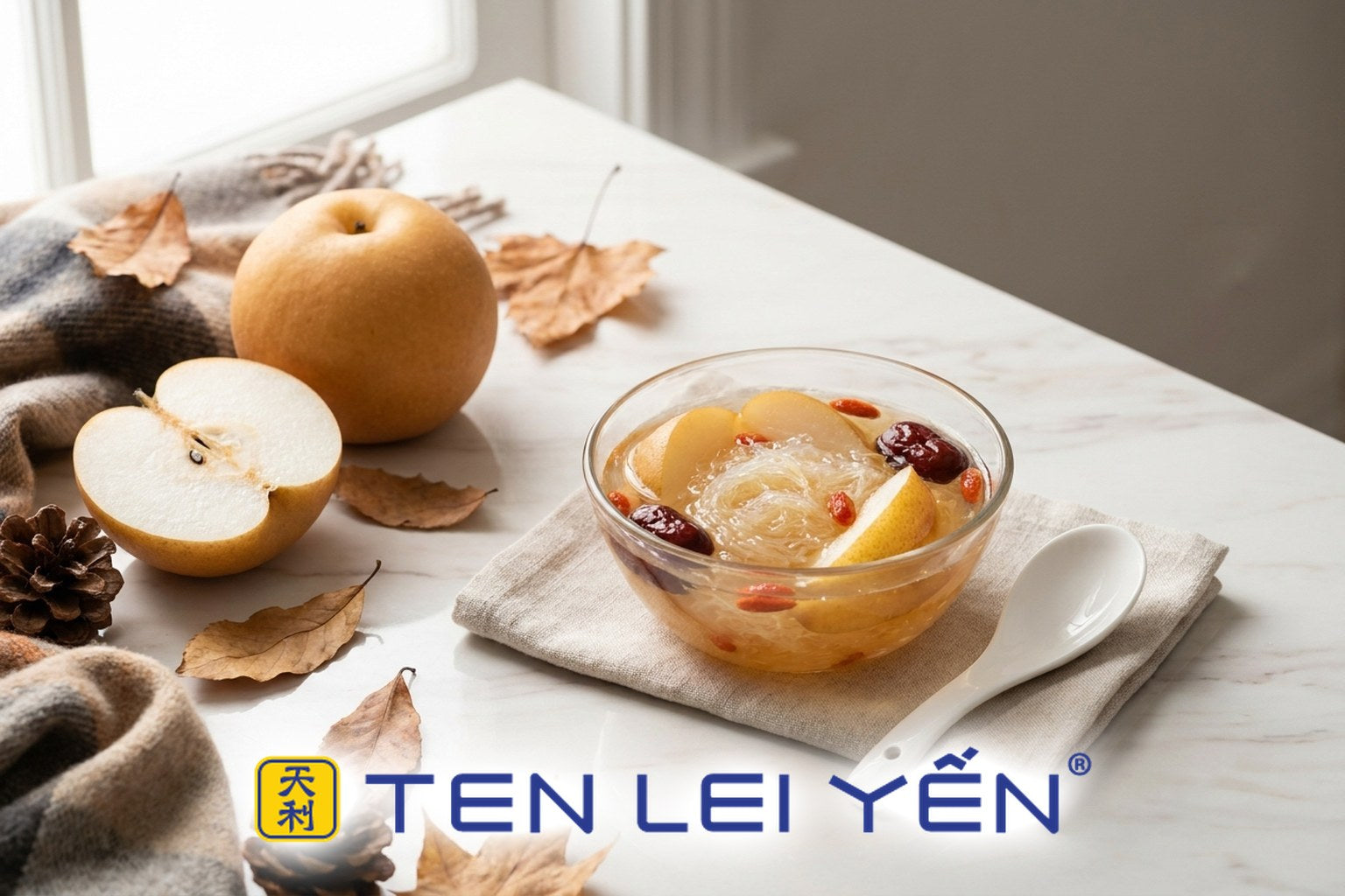 Warm double-boiled bird's nest with Asian pear, red dates, and goji berries in a glass bowl beside a whole and halved Asian pear