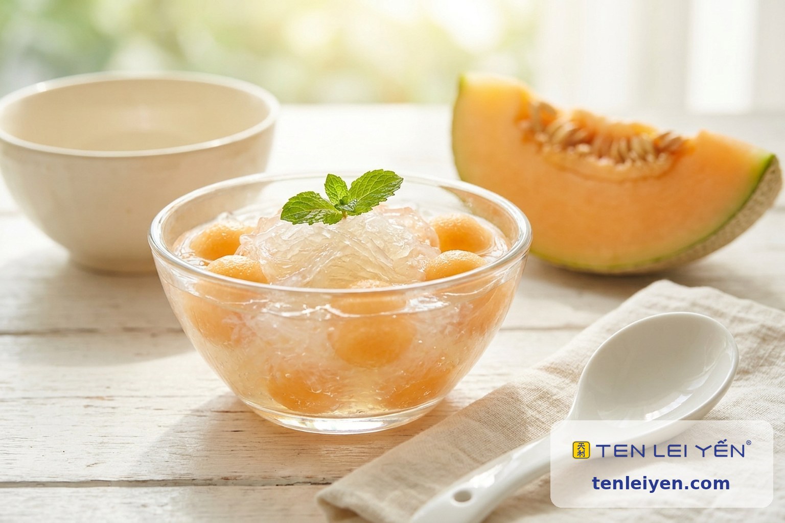 Chilled bird's nest topped with fresh cantaloupe melon balls in a footed glass coupe with a white porcelain spoon