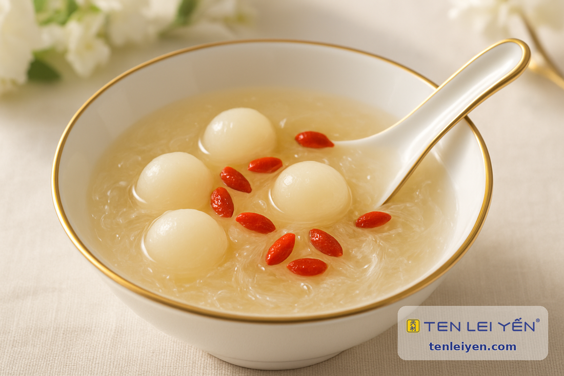 Chilled edible bird's nest dessert with fresh longan and goji wolfberries in a gold-rimmed porcelain bowl