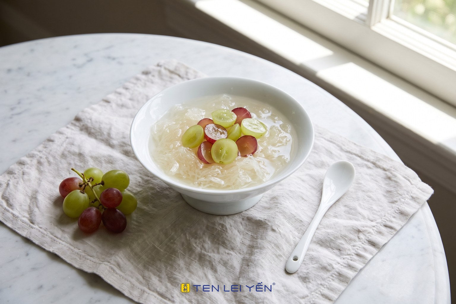 Chilled bird's nest with halved fresh green and red seedless grapes in a white porcelain bowl, a cool summer dessert