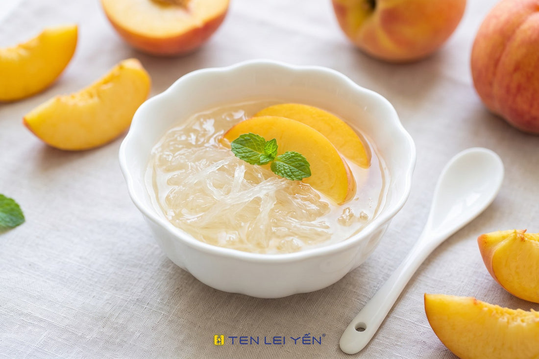 Chilled monk fruit bird's nest topped with fresh summer peach slices in a fluted white porcelain bowl