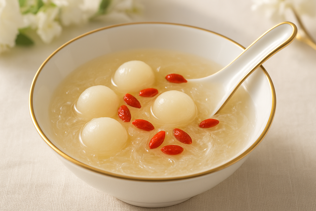 Chilled edible bird's nest dessert with fresh longan and goji wolfberries in a gold-rimmed porcelain bowl